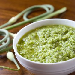 garlic scape pesto in white bowl on table.