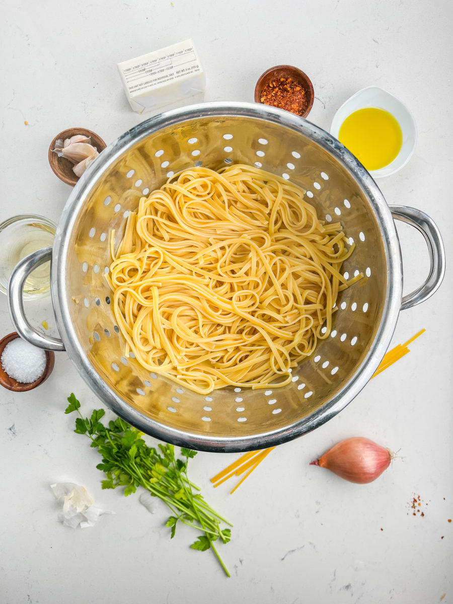 Cooked linguine pasta in colander. 