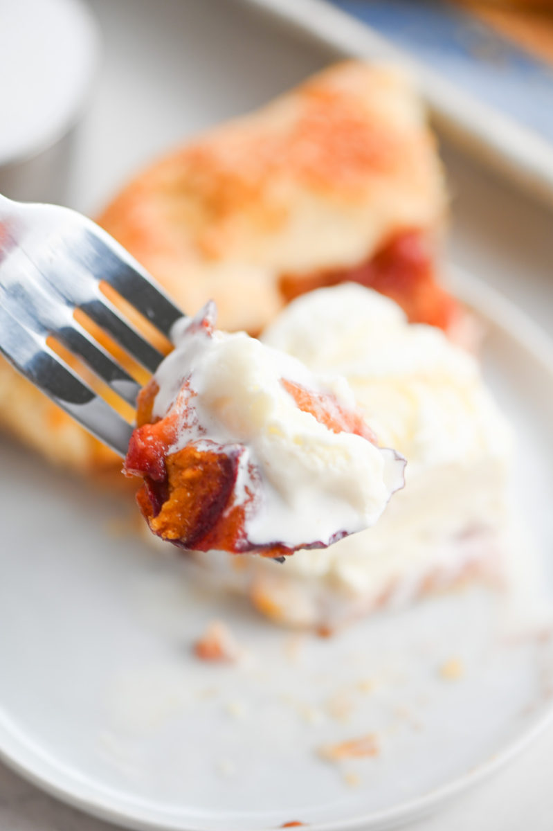 Forkful of peach galette with ice cream. 