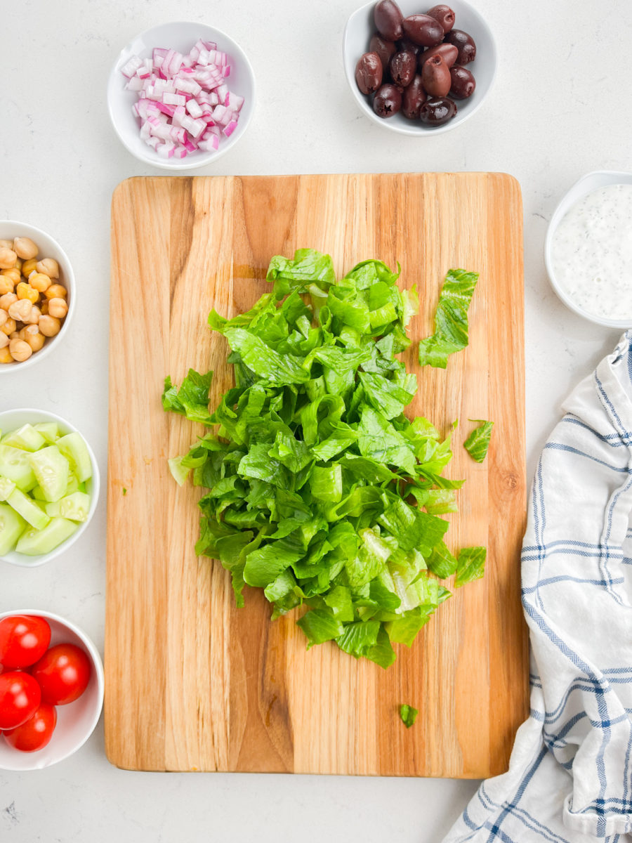 Chopped romaine lettuce on a wooden cutting board.