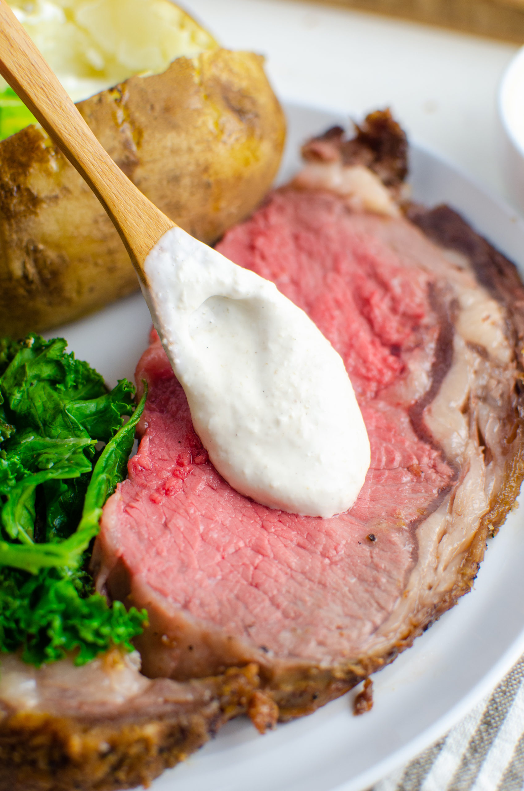 Spooning horseradish sauce on prime rib. 